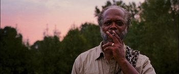 Movie still from “Black Snake Moan” (2006), directed by Craig Brewer – An older man smoking a cigarette in a park; Close Up shot, Low angle