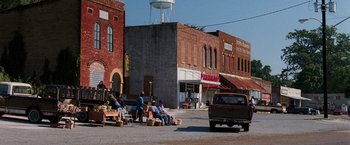 Movie still from “Black Snake Moan” (2006), directed by Craig Brewer – People sitting on benches on the side of the street; Extreme Wide shot, High angle