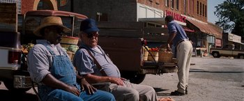 Movie still from “Black Snake Moan” (2006), directed by Craig Brewer – An older man sitting on a chair next to a truck; Medium shot, High angle