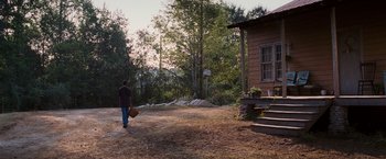 Movie still from “Black Snake Moan” (2006), directed by Craig Brewer – A person walking in a field near a house; Extreme Wide shot, High angle