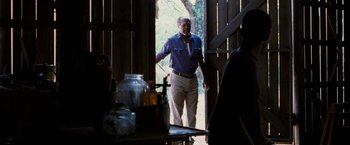 Movie still from “Black Snake Moan” (2006), directed by Craig Brewer – A man standing in a doorway of an old barn; Medium shot, Over the shoulder angle