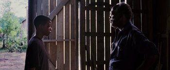 Movie still from “Black Snake Moan” (2006), directed by Craig Brewer – Two people standing next to each other near a wooden fence; Medium shot, Low angle