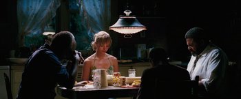 Movie still from “Black Snake Moan” (2006), directed by Craig Brewer – A woman sitting at a dinner table with a man; Medium shot, Over the shoulder angle