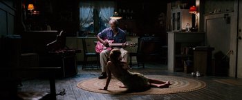 Movie still from “Black Snake Moan” (2006), directed by Craig Brewer – A man and a woman sitting on the floor with a guitar; Wide shot, High angle