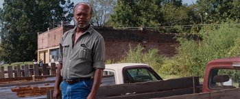 Movie still from “Black Snake Moan” (2006), directed by Craig Brewer – An older man standing in front of an old truck; Medium shot, Low angle