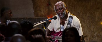 Movie still from “Black Snake Moan” (2006), directed by Craig Brewer – An older black man playing a guitar in front of an audience; Close Up shot, Low angle