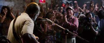Movie still from “Black Snake Moan” (2006), directed by Craig Brewer – A man is singing into a microphone in front of a crowd; Medium shot, Low angle