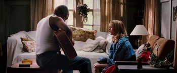 Movie still from “Black Snake Moan” (2006), directed by Craig Brewer – A man and a woman sitting in a living room with a guitar; Medium shot, Over the shoulder angle