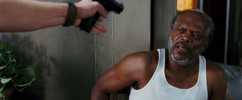 Movie still from “Black Snake Moan” (2006), directed by Craig Brewer – A man in a white tank top holding a gun; Close Up shot, Over the shoulder angle