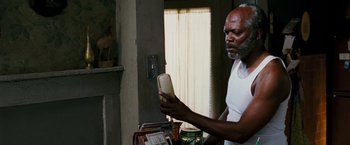 Movie still from “Black Snake Moan” (2006), directed by Craig Brewer – An older man holding a cell phone in his hand; Close Up shot, Over the shoulder angle