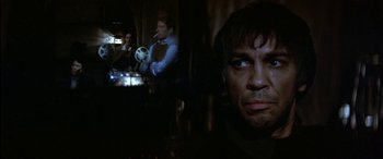 Movie still from “Black Sunday” (1977), directed by John Frankenheimer – A person with a camera in a room; Close Up shot, Over the shoulder angle