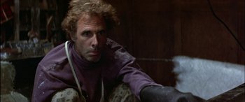 Movie still from “Black Sunday” (1977), directed by John Frankenheimer – A man sitting in a room with a knife in his hand; Close Up shot, Low angle