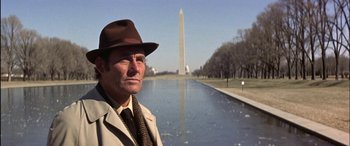 Movie still from “Black Sunday” (1977), directed by John Frankenheimer – A man wearing a hat standing in front of a body of water; Close Up shot, Low angle