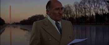 Movie still from “Black Sunday” (1977), directed by John Frankenheimer – A man in a suit and tie holding a piece of paper; Close Up shot, Low angle