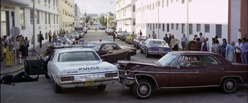 Movie still from “Black Sunday” (1977), directed by John Frankenheimer – An old police car parked on the side of the street; Extreme Wide shot, High angle