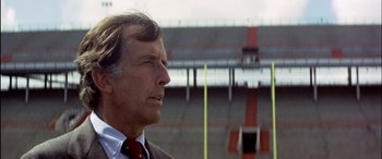 Movie still from “Black Sunday” (1977), directed by John Frankenheimer – An older man in a suit and red neck tie; Close Up shot, Low angle