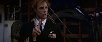 Movie still from “Black Sunday” (1977), directed by John Frankenheimer – A man in a uniform giving the peace sign; Close Up shot, Low angle