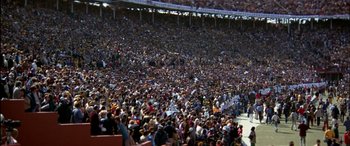 Movie still from “Black Sunday” (1977), directed by John Frankenheimer – A large crowd of people in a large stadium; Extreme Wide shot, High angle