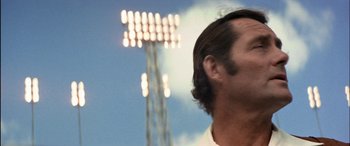 Movie still from “Black Sunday” (1977), directed by John Frankenheimer – A man's face in front of a stadium light; Close Up shot, Low angle