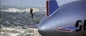 Movie still from “Black Sunday” (1977), directed by John Frankenheimer – A man hanging from the side of an airplane; Extreme Wide shot, Low angle