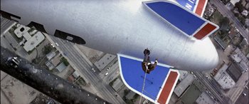 Movie still from “Black Sunday” (1977), directed by John Frankenheimer – A man hanging from the side of an airplane; Extreme Wide shot, Overhead angle