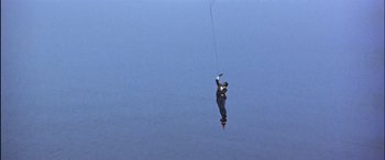 Movie still from “Black Sunday” (1977), directed by John Frankenheimer – A man is flying a kite high in the sky; Extreme Wide shot, Low angle
