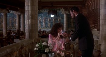 Movie still from “Blame It on Rio” (1984), directed by Stanley Donen – A man and a woman are sitting at a dinner table; Medium shot, Over the shoulder angle