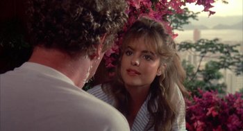 Movie still from “Blame It on Rio” (1984), directed by Stanley Donen – A young woman looking at a man in front of a tree; Close Up shot, Over the shoulder angle