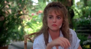 Movie still from “Blame It on Rio” (1984), directed by Stanley Donen – A person sitting in a chair; Close Up shot, Over the shoulder angle