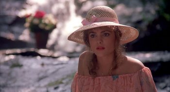 Movie still from “Blame It on Rio” (1984), directed by Stanley Donen – A woman wearing a pink dress and a pink hat; Close Up shot, Over the shoulder angle