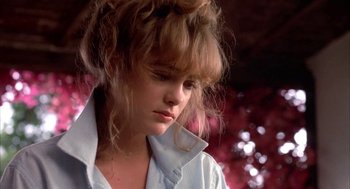 Movie still from “Blame It on Rio” (1984), directed by Stanley Donen – A young woman with long blonde hair wearing a white shirt; Close Up shot, Low angle