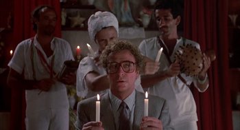 Movie still from “Blame It on Rio” (1984), directed by Stanley Donen – A group of people holding lit candles in front of a man; Medium shot, Low angle