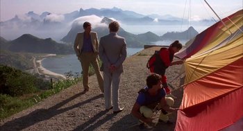 Movie still from “Blame It on Rio” (1984), directed by Stanley Donen – A group of people standing on top of a hill; Wide shot, Low angle