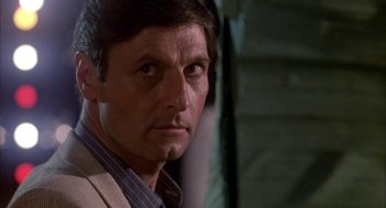 Movie still from “Blame It on Rio” (1984), directed by Stanley Donen – A person wearing a suit and tie; Close Up shot, Low angle