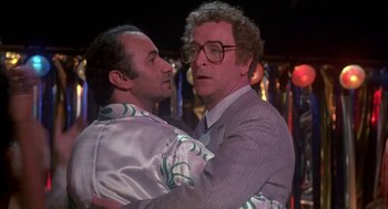 Movie still from “Blame It on Rio” (1984), directed by Stanley Donen – A couple of men standing next to each other; Medium shot, Over the shoulder angle