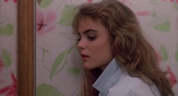 Movie still from “Blame It on Rio” (1984), directed by Stanley Donen – A woman with long brown hair wearing a white dress shirt; Close Up shot, Over the shoulder angle