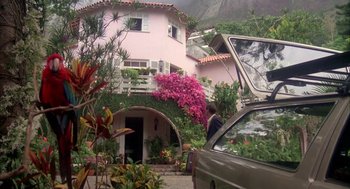 Movie still from “Blame It on Rio” (1984), directed by Stanley Donen – A car parked in front of a pink house; Extreme Wide shot, Low angle