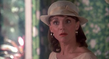 Movie still from “Blame It on Rio” (1984), directed by Stanley Donen – A person wearing a hat; Close Up shot, Over the shoulder angle