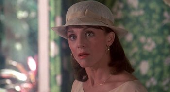 Movie still from “Blame It on Rio” (1984), directed by Stanley Donen – A person wearing a hat and looking at the camera; Close Up shot, Over the shoulder angle