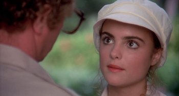 Movie still from “Blame It on Rio” (1984), directed by Stanley Donen – A woman wearing a white hat looking at a man; Close Up shot, Over the shoulder angle