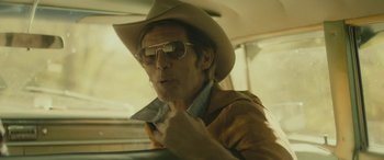 Movie still from “Blaze” (2018), directed by Ethan Hawke – A man in a cowboy hat and sunglasses in a car; Close Up shot, Over the shoulder angle