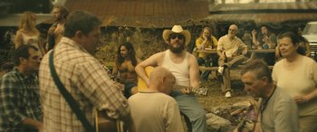 Movie still from “Blaze” (2018), directed by Ethan Hawke – A group of people sitting around a table; Medium shot, Over the shoulder angle