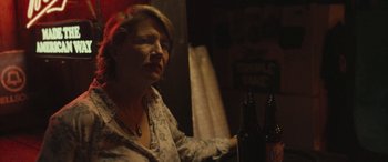 Movie still from “Blaze” (2018), directed by Ethan Hawke – A woman sitting at a table with two beer bottles; Close Up shot, Over the shoulder angle