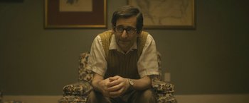 Movie still from “Blaze” (2018), directed by Ethan Hawke – A man sitting in a chair with his hands crossed; Medium shot, Over the shoulder angle