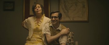 Movie still from “Blaze” (2018), directed by Ethan Hawke – A man and a woman sitting next to each other on a couch; Medium shot, High angle