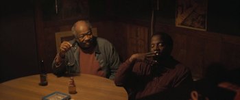 Movie still from “Blaze” (2018), directed by Ethan Hawke – Two men sitting at a table in front of each other; Medium shot, Over the shoulder angle