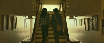 Movie still from “Blaze” (2018), directed by Ethan Hawke – Two people holding hands while walking up a flight of stairs; Medium shot, Low angle