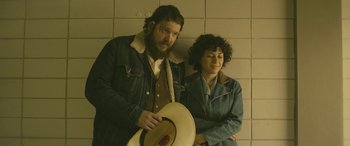 Movie still from “Blaze” (2018), directed by Ethan Hawke – A man and a woman standing next to each other; Medium shot, Low angle
