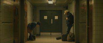 Movie still from “Blaze” (2018), directed by Ethan Hawke – Two men are standing in front of a door; Wide shot, High angle