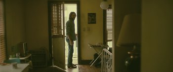 Movie still from “Blaze” (2018), directed by Ethan Hawke – A man standing in front of an open door; Wide shot, Low angle
